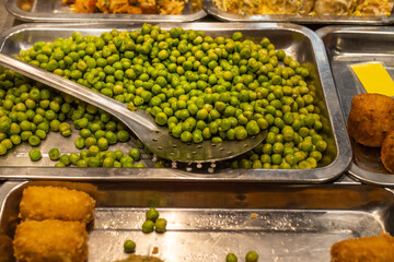 Cooked peas in an aluminum tray ready to eat in a market.