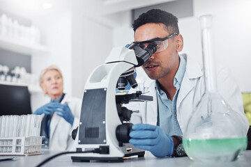 Science, microscope and innovation with a doctor man in a laboratory for research or medical...