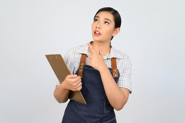 Obraz premium Portrait of young asian woman in waitress uniform pose with clipboard