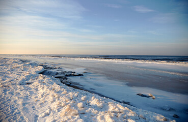 Winter landscape with icy sea coast and calm blue sky, selective focus