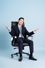 Asian businessman male portrait sitting on chair and isolated on blue background