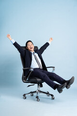 Asian businessman male portrait sitting on chair and isolated on blue background