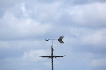 A weather vane against a cloudy sky
