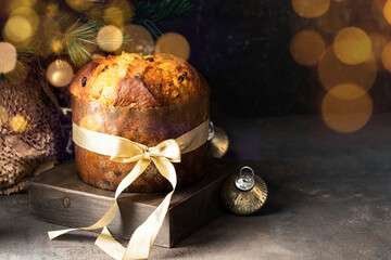 Traditional Italian Christmas cake, Panettoni  with raisins and candied fruits on wooden try with...