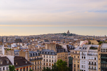 Fototapeta na wymiar City day view of Parisian rooftops and Sacre-Coeur minor basilica from Centre Pompidou. Sacred Heart church in Montmartre hill. Popular landmark in Paris, France. Horizontal background and copy space.