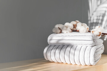 Fototapeta na wymiar Bath fresh towels pile soft textile cotton body care neatly folded white gray laundry flower shelf