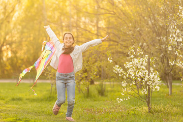Plakat little cute girl flying a kite on a sunny day