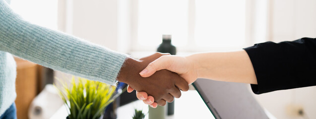 Closeup handshake in the office. Unrecognizable multiethnic people with copy space in horizontal banner or header.