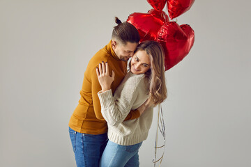 Happy couple in love enjoying Saint Valentine's Day together. Young man hugs his beloved woman,...