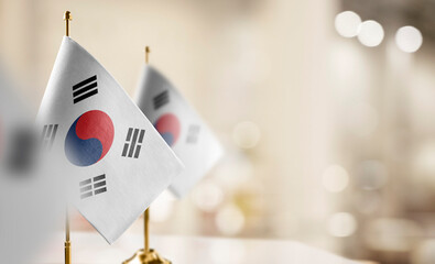 Small flags of the South Korean on an abstract blurry background - obrazy, fototapety, plakaty