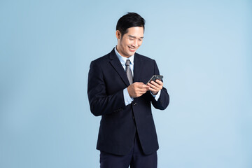 portrait of asian businessman wearing suit on blue background