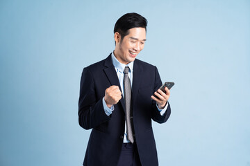 portrait of asian businessman wearing suit on blue background