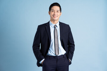 portrait of asian businessman wearing suit on blue background