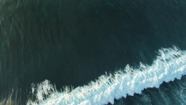 Aerial view of wave at sunrise or sunset. Surfing waves in ocean