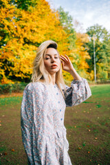 Portrait of attractive caucasian woman posing in the autumn park.