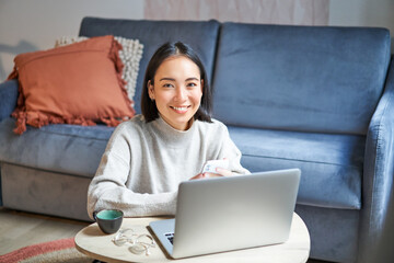 Work from home, freelance and e-learning concept. Young woman studying, sitting in front of laptop,...