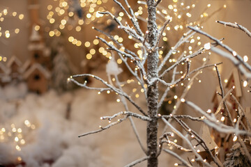 Snowy branches decoration with gold  festive lights bokeh. Winter holiday home yard decor. Snow backdrop.