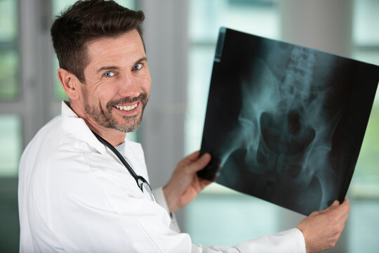happy doctor examining x-ray images of patient