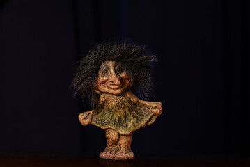 Clay doll of a smiling troll girl.