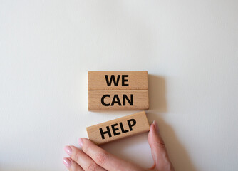 We can help symbol. Wooden blocks with words We can help. Beautiful white background. Businessman...