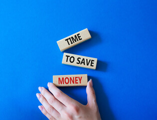 Time to save money symbol. Wooden blocks with words Time to save money. Businessman hand. Beautiful blue background. Business and Time to save money concept. Copy space.