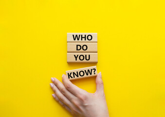 Who do you know symbol. Concept words Who do you know on wooden blocks. Beautiful yellow background. Businessman hand. Business and Who do you know concept. Copy space