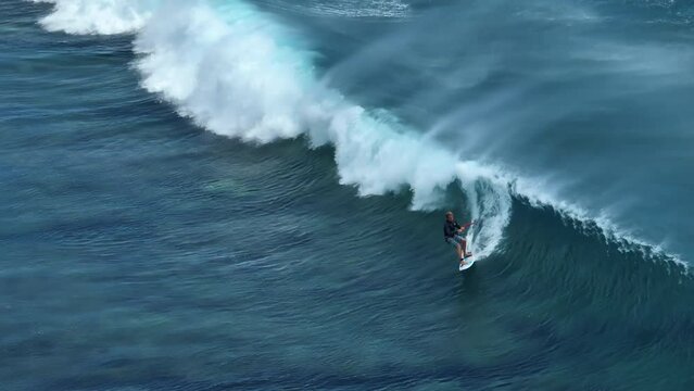 An athlete on a wave board rides the big ocean waves of a living reef in the Indian Ocean. One of the best surf spots on the planet. Sports hobby