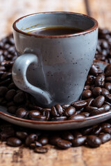 a cup of coffee with roasted beans on a wooden background, photographed from the front