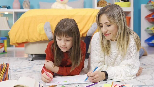 Creative and dreamy little girl draws picture with her mother.
The talented little girl draws pictures with her mother in her room at home, they have fun and they have joyful moments.
