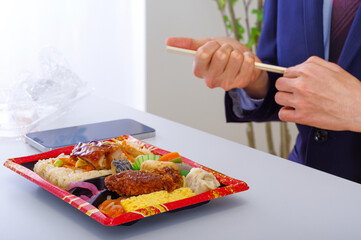 コンビニ弁当を食べるビジネスパーソン