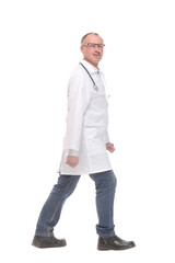 Fototapeta premium Middle age doctor with stethoscope walking on white background