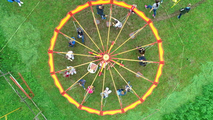 Carnival Merry Go Round aerial top view. Drone tracking rotation shoot. 