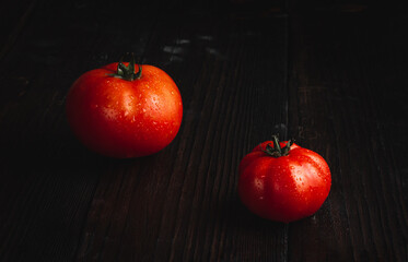 Ripe tomatoes in low key. Tomatoes on the table.