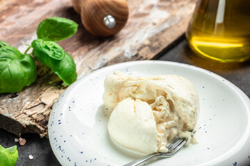 fresh handmade soft Italian cheese from Puglia, white balls of burrata or burratina cheese Basil and Olive Oil and Ciabatta. place for text, top view