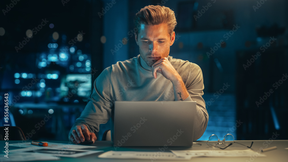 Leinwandbilder handsome man working on laptop computer in a company office at night. young specialist analyzing rep