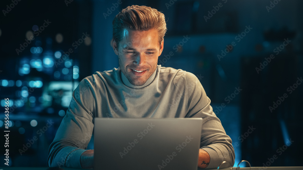 Leinwandbilder handsome man working on laptop computer in a company office at night. young specialist analyzing rep