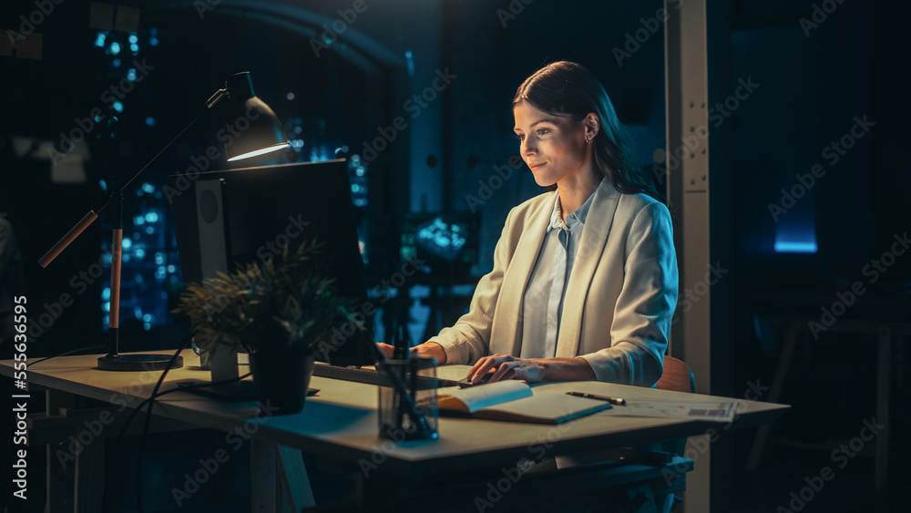 Poster portrait of a young accountant working in the office late in the evening. positive female using desk