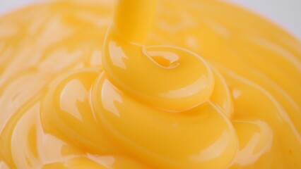 Pour yellow cheese sauce close up