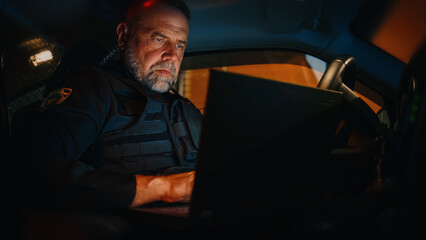 Inside Police Traffic Patrol Squad Car: White Male Police Officer on Duty Uses Laptop to Check...