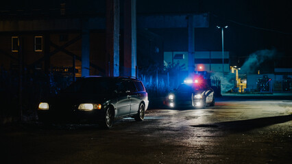 Highway Traffic Patrol Car In Pursuit of Criminal Vehicle, Traffic Stop, Pull Over, Arrest. Police Officer Gets out of Squad Car, Approaches Suspect. Cinematic Action in Industrial Urban Area at Night