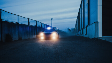 Traffic Patrol Car in Pursuit through Industrial Area. Police Officers Driving Squad Car, Chasing...