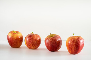 Four fresh red apples on a white background.