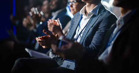 Close Up on Hands of a Crowd of People Clapping in Dark Conference Hall During a Motivational Keynote Presentation. Business Technology Summit Auditorium Room Full of Delegates. - obrazy, fototapety, plakaty