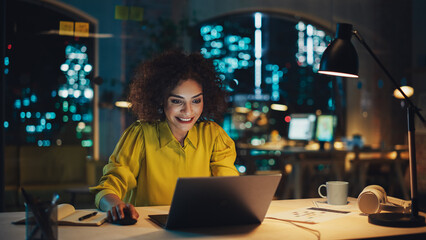 Creative Multiethnic Female Working on Laptop Computer in a Company Office. Happy Project Manager Browsing Internet, Writing Tasks, Developing a Marketing Strategy for Clients.