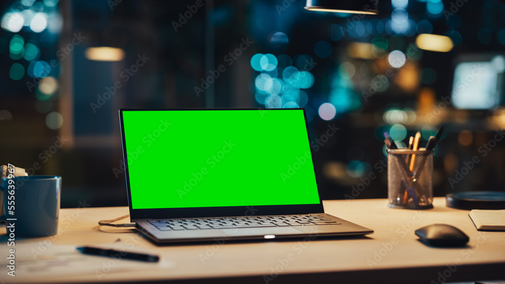 Aufkleber laptop standing on a desk with a green screen chromakey mock up display. table with computer, coffee