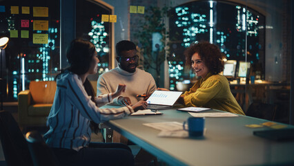 Excited Marketing Manager Leading a Team Meeting in Creative Office Conference Room in the Evening. Confident Multiethnic Female Discussing a New Project Plan with Agency Employees.