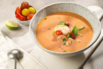 a spicy thai coconut soup or curry made of coconut milk, cherry tomatoes, snow pea, chili pepper,...
