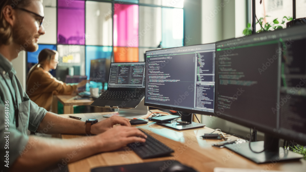 Poster Male Programmer Coding on Desktop Computer With Two Monitors Set Up in Creative Office. Caucasian Man Using Artificial Intelligence to Create Innovative Software for Start-up Company.