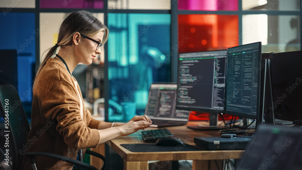 Fototapete Young Caucasian Woman Programming On Desktop Computer With Two Monitors Setup in Spacious Office. Female Software Developer Creating SaaS Platform For Businesses in Innovative Start-up Company.