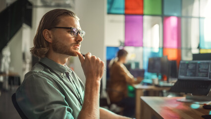Professional Male Programmer Writing Code on Desktop Computer With Multiple Displays Setup in Stylish Office. Caucasian Man Does Data Scraping For Artificial Intelligence Innovative Start-Up.